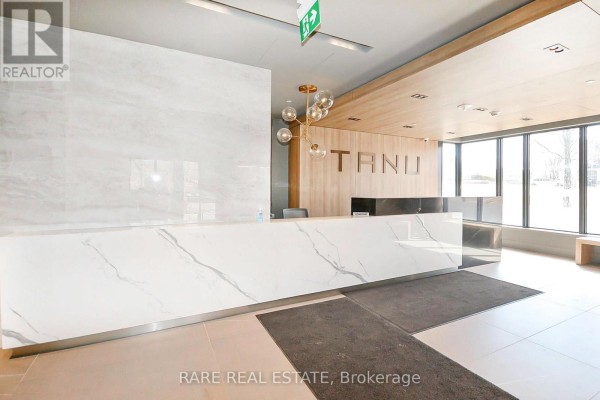 Reception desk with a white marble front and wooden accents. - 308 - 21 Park Street E, Mississauga