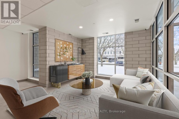 Lobby seating area with beige stone walls, contemporary furniture, and large windows. - 308 - 351 Hill Street, London East