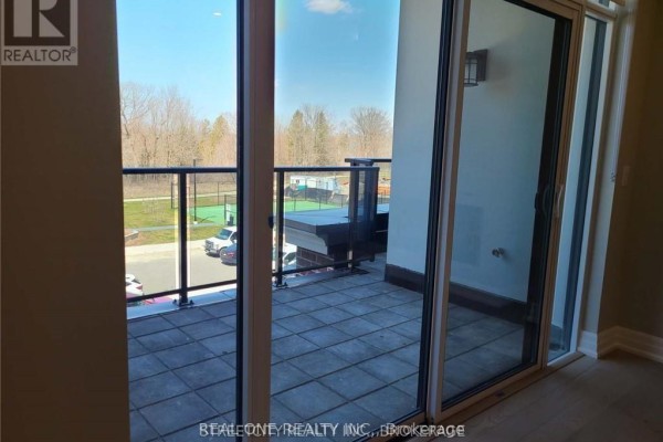 View from the balcony overlooking a courtyard with a tennis court and trees. - 308 - 480 Callaway Road, London North