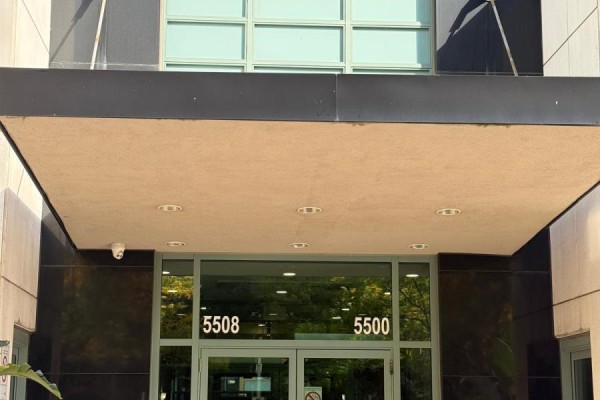 A kitchen with wooden cabinets, a white refrigerator, stainless steel stove, and a double sink. - 308 - 5508 Yonge Street Ne, Toronto