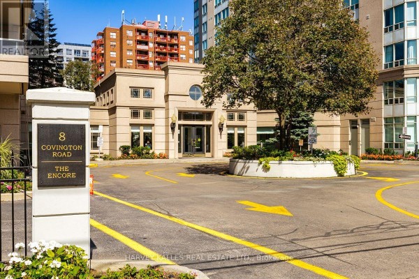 Entrance to The Encore apartment building at 8 Covington Road with a circular driveway. - 308 - 8 Covington Road, Toronto