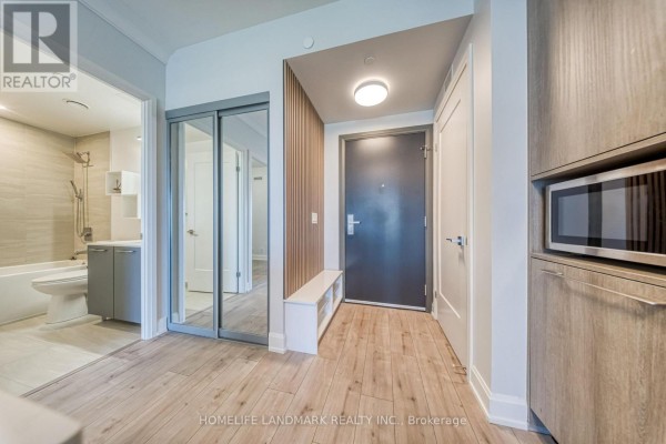 Dining area with two chairs, a small table, and kitchen cabinets in the background. - 308 - 8 Water Walk Drive, Markham
