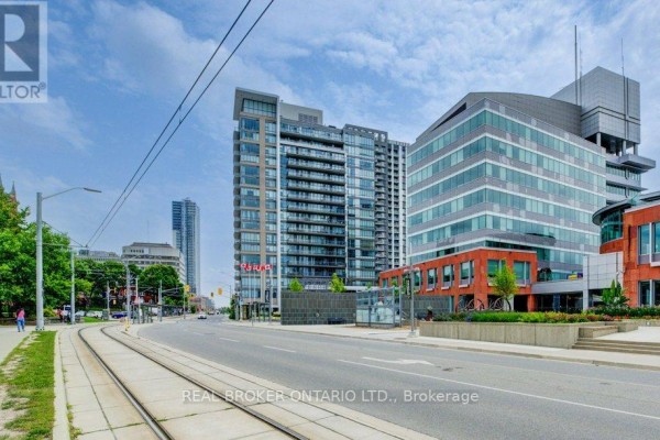 Street view of apartment building with streetcar tracks and traffic. - 308 - 85 Duke Street W, Kitchener