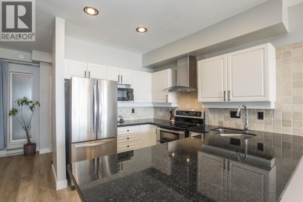 Fitness room with cardio machines, weight rack, and rubber flooring. - 308 1120 Tsatsu Shores Drive, Tsawwassen