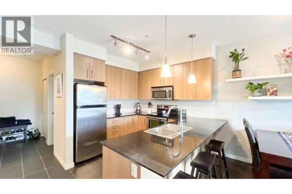 Balcony with seating area and view of trees and parking lot. - 308 22290 North Avenue, Maple Ridge