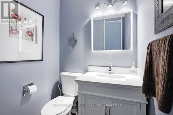 Powder room with light blue walls, white vanity, and toilet. - 308 Lafontaine Avenue, Ottawa