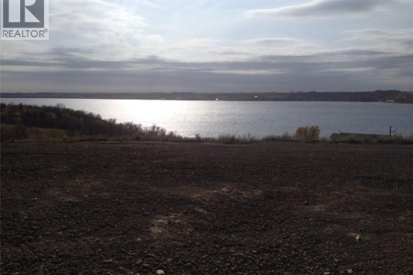 Landscape view of the lake reflecting sunlight, with a clear sky and distant hills. - 308 Mckillop Road, Last Mountain Lake