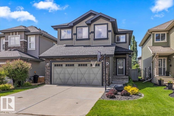 Front view of the house, showing the driveway, garage door, and front entrance. - 3082 Whitelaw Dr Nw, Edmonton