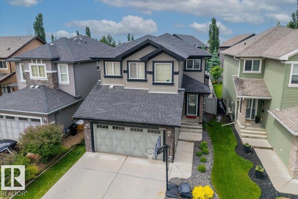 Aerial view of the house, highlighting its roof, second story windows, and surrounding landscaping. - 3082 Whitelaw Dr Nw, Edmonton