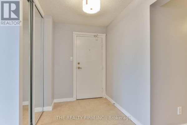 Entryway of the apartment with a light fixture and mirrored closet doors. - 309 - 570 Proudfoot Lane, London North