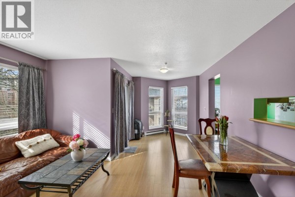 Cozy seating area with leather chairs, stone fireplace, and large window for natural light. - 309 2435 Welcher Avenue, Port Coquitlam