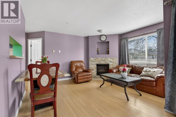 Close-up of leather sofa and stone fireplace, featuring decorative items on the mantel. - 309 2435 Welcher Avenue, Port Coquitlam
