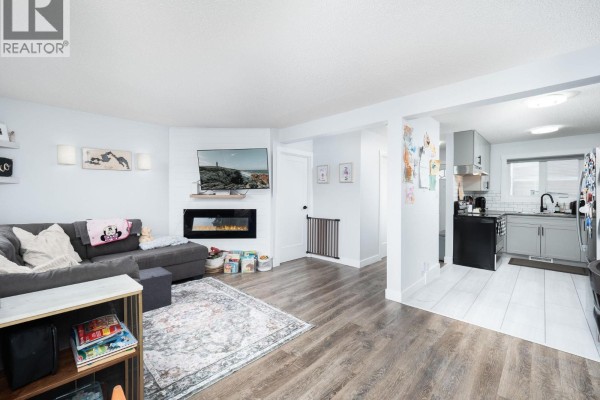 Open concept living room and kitchen with grey cabinets and stainless steel appliances. - 309 2550 S Ospika Boulevard, Prince George