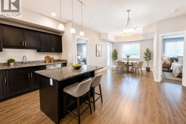 Living space with bunk beds, sofa, desk, television, and gray wood-look flooring. - 309 412 Willowgrove Square, Saskatoon