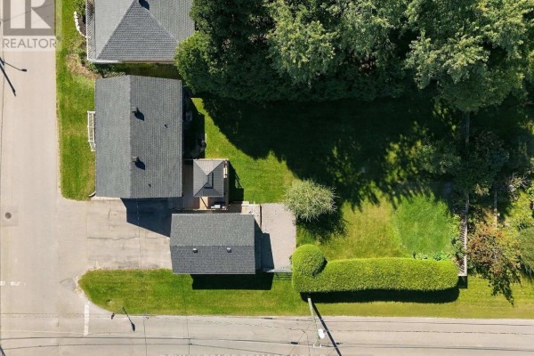 Overhead view of a property showing a bungalow, detached garage, and backyard with mature trees. - 309 George Street East, North Grenville