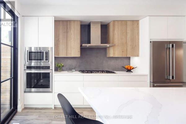 Modern kitchen with stainless steel appliances, white and wood cabinets, and hardwood floors - 309 Wychwood Avenue Toronto