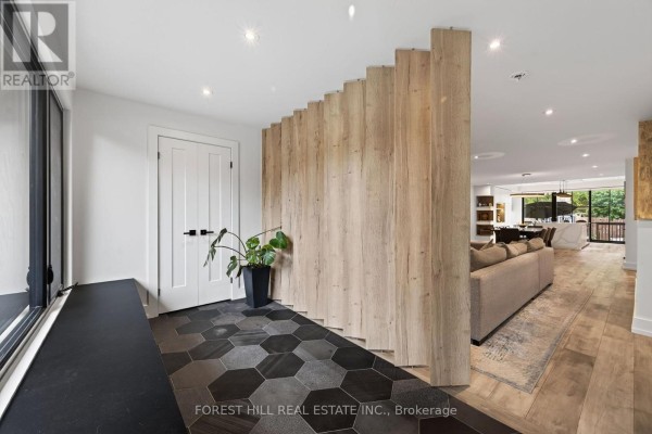 Interior entryway with a large window, black bench, and geometric tiled floor. - 309 Wychwood Avenue, Toronto