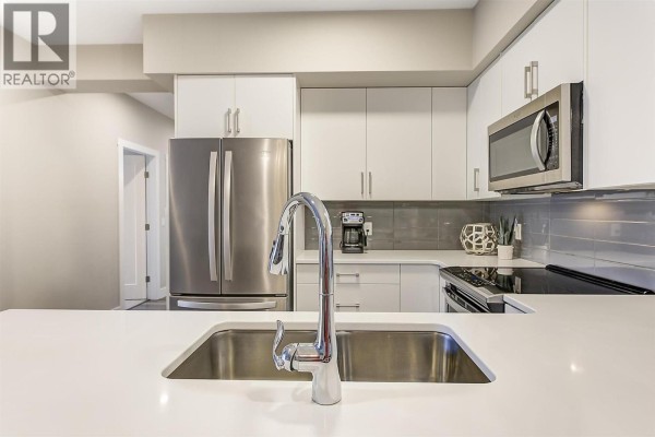 Building hallway with elevator, plant, and storage doors. - 3090 Burtch Road Unit# 201, Kelowna