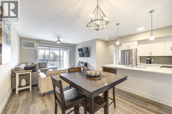 Kitchen with stainless steel stove, microwave, and white cabinets. - 3090 Burtch Road Unit# 201, Kelowna