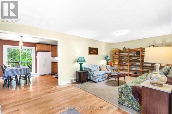 Living room with light yellow walls, two floral sofas, and wooden floorboards. - 3099 8th Concession North Road, Mississippi Mills