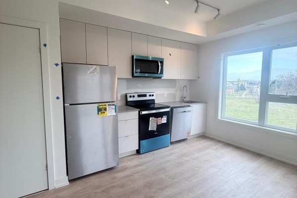 Kitchenette with stainless steel appliances, light grey cabinets, and a large window with a view. - 309b - 16 Melbourne Avenue, St  Catharines
