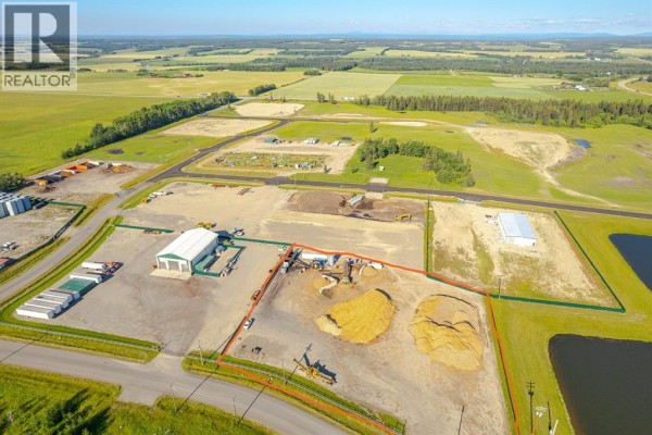 Aerial view showing property boundaries demarcated in red, with industrial buildings. - 31, 32532 Range Road 42, Rural Mountain View County