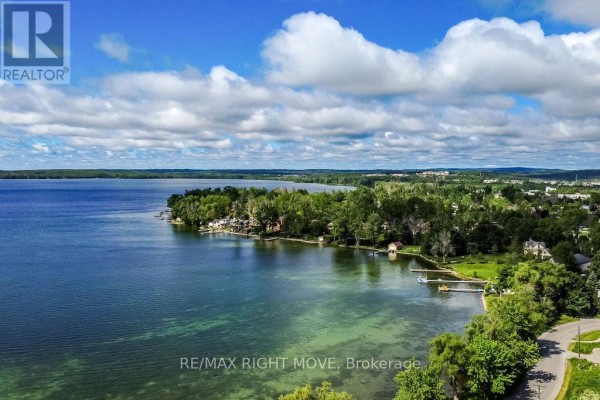 Aerial view of a wide bay with trees, houses, and a distant town skyline. - 31 - 12 Lankin Boulevard, Orillia