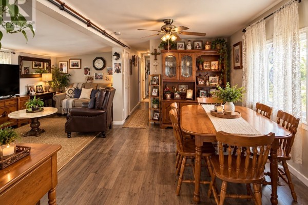 Open concept living and dining area with wooden furniture, dining table, hutch, and ceiling fan. - 31-15 Fish Hatchery Rd, Sault Ste  Marie