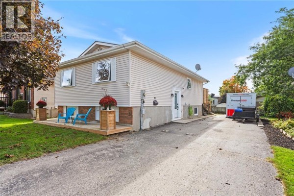 Side view of a residential house with a driveway and a storage unit. - 31 Beckett Boulevard, Tillsonburg