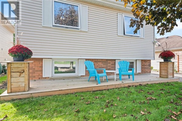 Close-up of a wooden deck with two blue chairs and a small white table. - 31 Beckett Boulevard, Tillsonburg