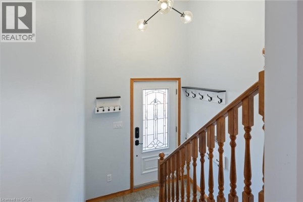 Interior view of a home entrance with a staircase and a white door. - 31 Beckett Boulevard, Tillsonburg