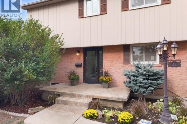 Front entrance of a house with a glass-paneled door, porch, and landscaping. - 31 Berrisfield Crescent, Hamilton