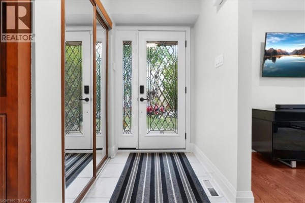 Bright entryway with white walls, mirrored closet doors, and a striped rug. - 31 Berrisfield Crescent, Hamilton