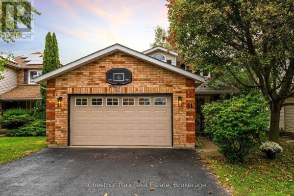 Front view of a two-story house with a brick facade, beige garage door, and basketball hoop. - 31 Bush Street, Collingwood
