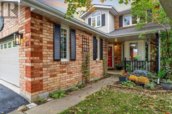 Close-up of the side of a house showing brickwork, garage door, entryway, and autumn foliage. - 31 Bush Street, Collingwood