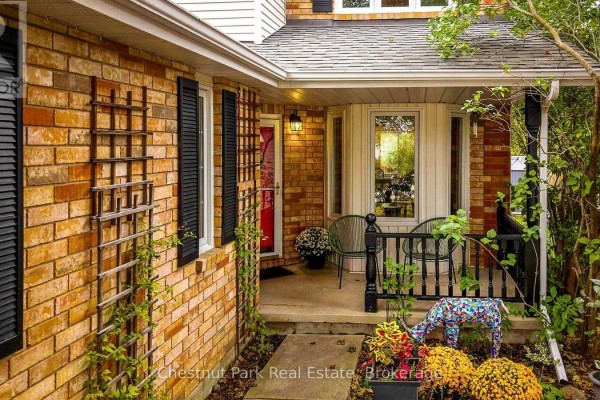 View of the house entrance with a porch, black railing, seating, and decorative garden elements. - 31 Bush Street, Collingwood