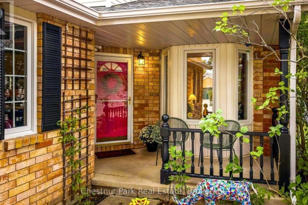 Entrance to the house featuring a red front door, brick walls, bay window, and porch details. - 31 Bush Street, Collingwood