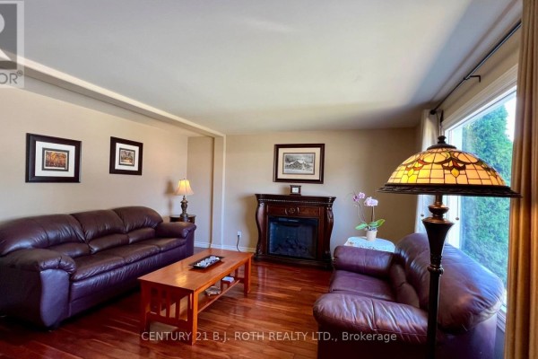 Kitchen with white cabinets, granite countertops, stainless steel appliances, and a glass door. - 31 Corner Brook Trail, Innisfil
