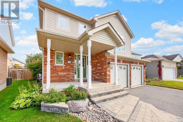 Close-up view of the covered front porch with brick pillars and a green front door. - 31 Country Lane, Barrie