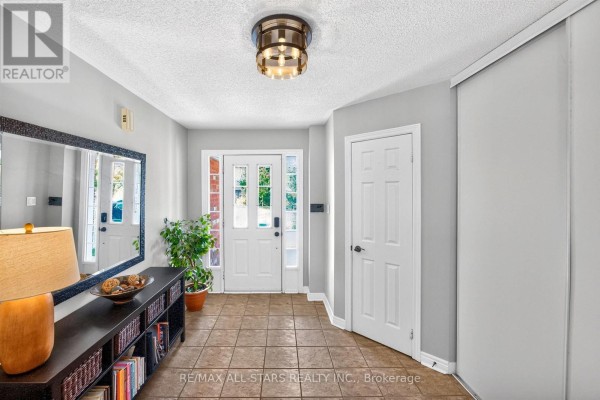 Foyer with beige tile floors, white walls, a large mirror, and a glass-paneled front door. - 31 Country Lane, Barrie