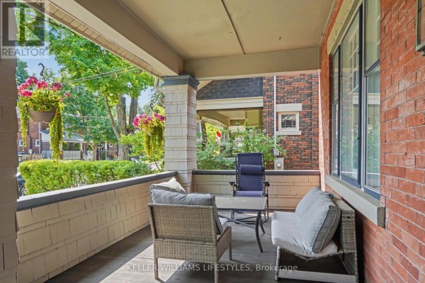 Covered front porch with wicker furniture including a loveseat, armchair, and a glass-top table. - 31 Gerrard Street, London South