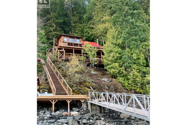 Loft area with sloped wooden ceiling, foosball table, and two beds - 31 Lime Cliffs Beach, Sicamous