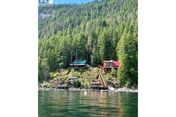 Kitchen featuring white cabinets, stainless steel appliances, and dark countertops - 31 Lime Cliffs Beach, Sicamous