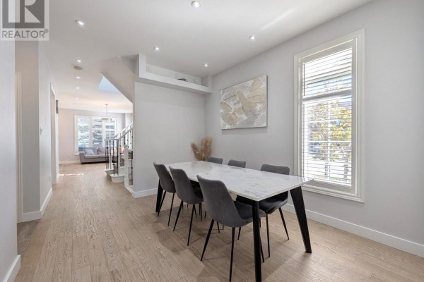 Dining room with a marble-top table, grey chairs, light wood floors, and a view of the hallway. - 31 Loire Valley Avenue, Vaughan