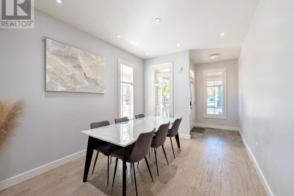 Dining room with a marble-top table, grey chairs, light wood floors, and a view of the entryway. - 31 Loire Valley Avenue, Vaughan