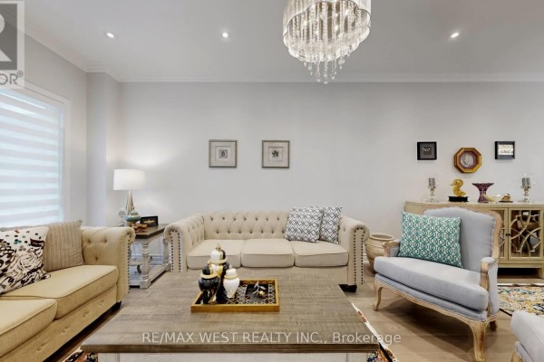 Living room with light grey walls, tufted beige sofa, grey armchair, and coffee table. - 31 Mulholland Drive, Vaughan