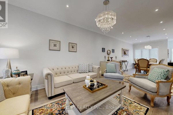 Living room with dining area in the background, beige sofas, and a crystal chandelier. - 31 Mulholland Drive, Vaughan