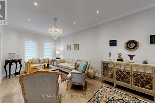 Living room with ornate mirrored cabinet, beige furniture, crystal chandelier, and light wood floors. - 31 Mulholland Drive, Vaughan
