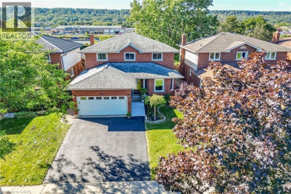 Aerial view of a brick two-storey house with a white garage door and landscaping. - 31 Princess Boulevard, Grimsby
