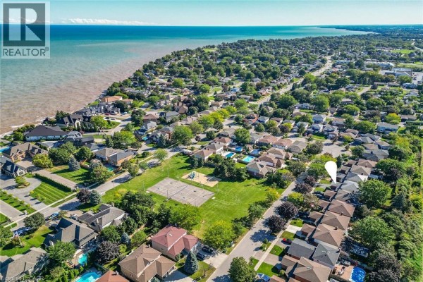 Aerial view of a suburban neighborhood with houses, a park, and Lake Ontario in the distance. - 31 Princess Boulevard, Grimsby